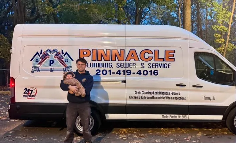 Drew Ryder of Pinnacle Plumbing with his daughter by the company van